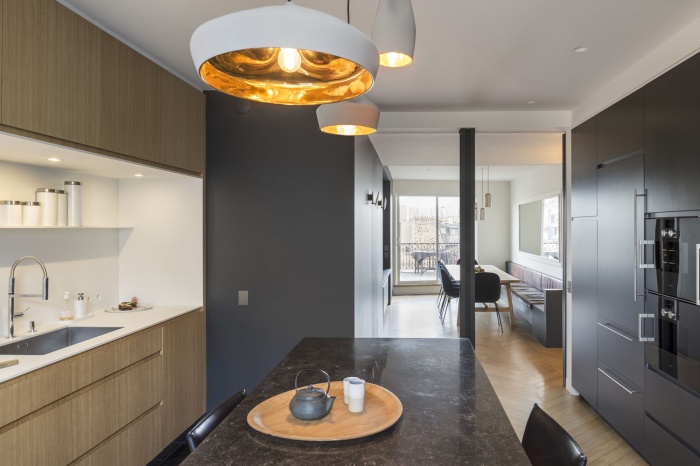 Boulainvillers : Transformation de deux chambres bien cloisonnées, en un espace cuisine/salle à manger traversant. La cuisine est ouverte sur le coin repas. Les parois vitrées coulissantes permettent, selon l’usage des habitants, de fermer l’espace de la cuisine tout en c